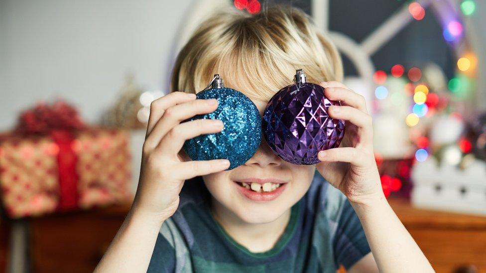 boy-holding-baubles-over-eyes.