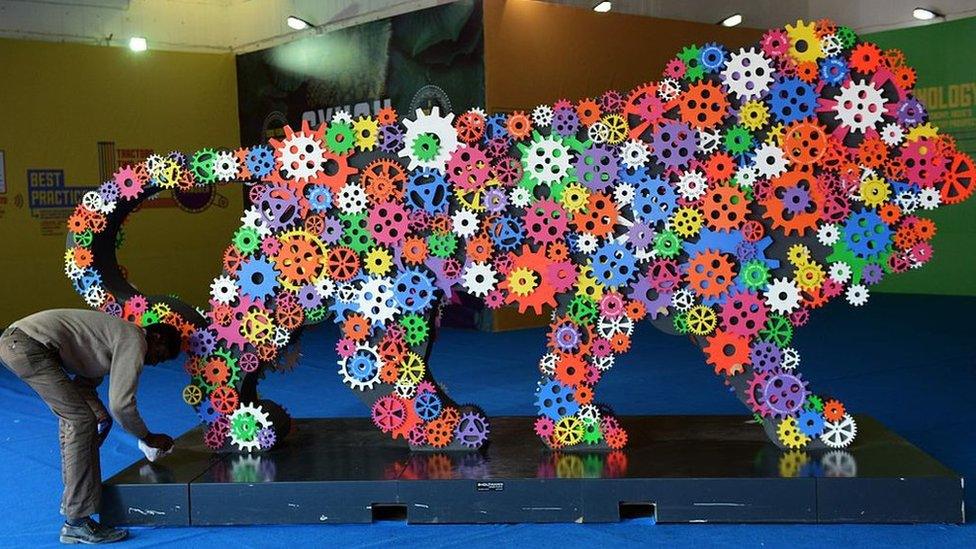 An Indian worker cleans an installation of the 'Make In India' logo at the 35th India International Trade fair in New Delhi on November 17, 2015