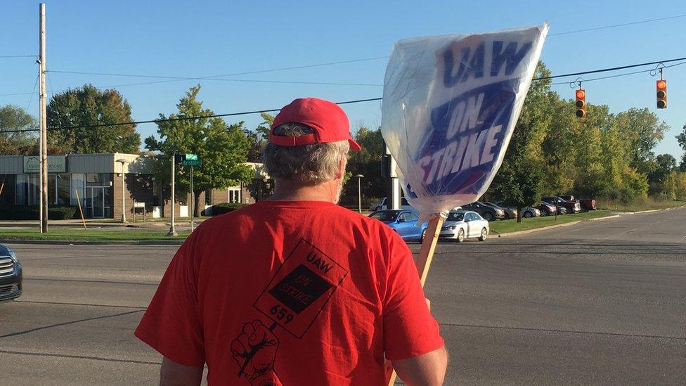 Worker holding a sign "UAW on Strike"