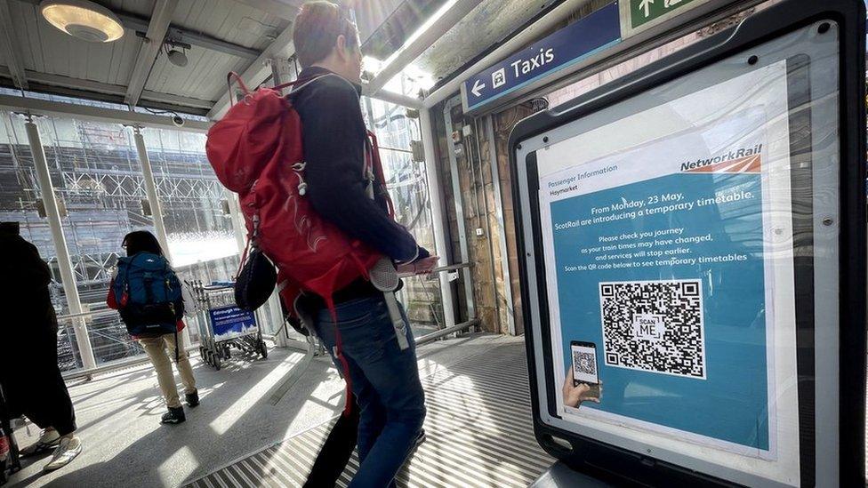 passenger looks at sign in Haymarket Station