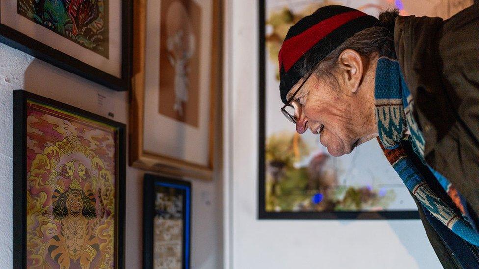 Man looks at picture on the wall at last year's event