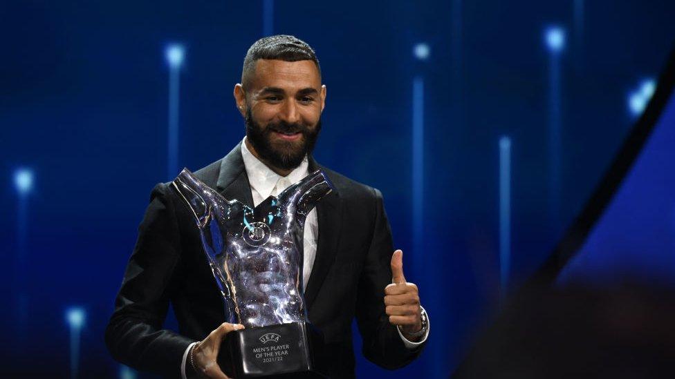 UEFA Men's Player of the Year Karim Benzema poses with their award on stage during the UEFA Champions League