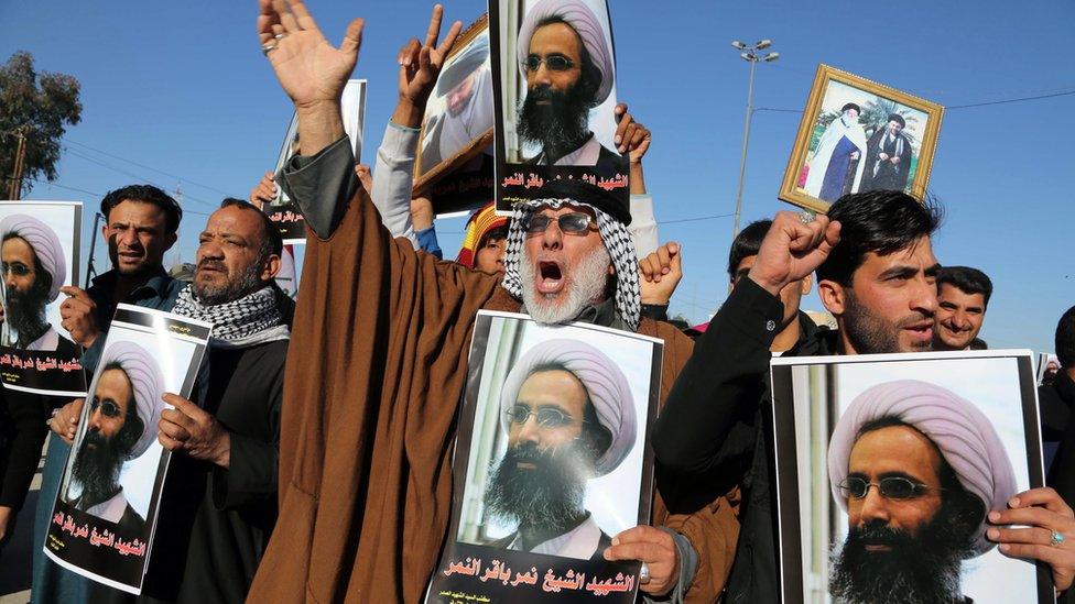 Iraqi Shia protesters chant slogans against the Saudi government as they hold posters showing Sheikh Nimr al-Nimr