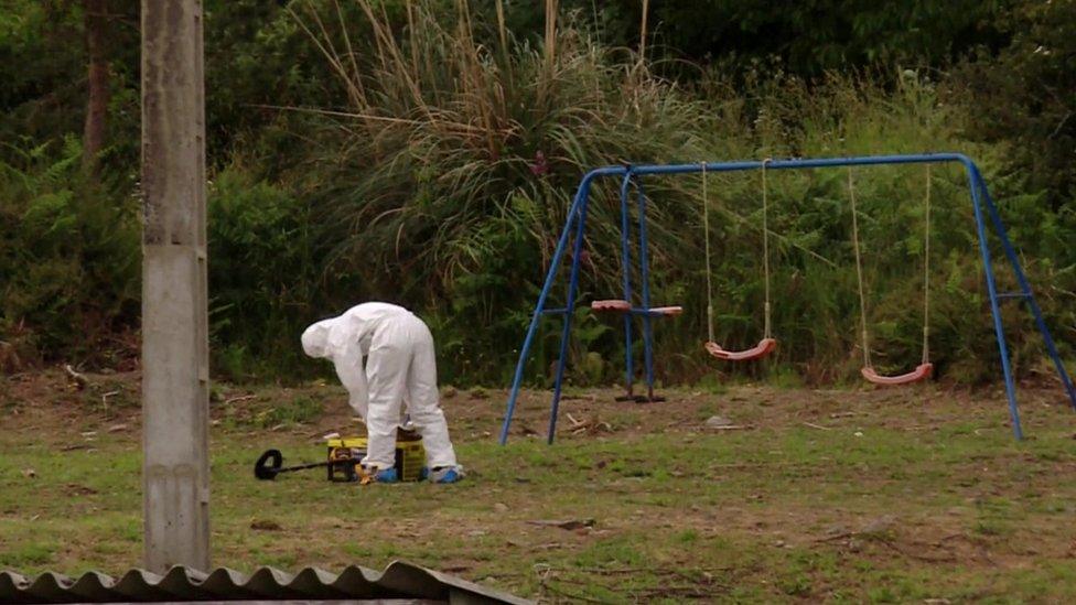 Forensic officer in garden with swings