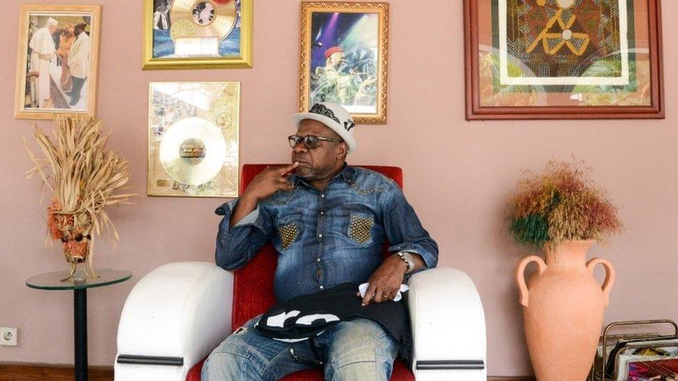 Papa Wemba posing in Kinshasa with some of his gold discs