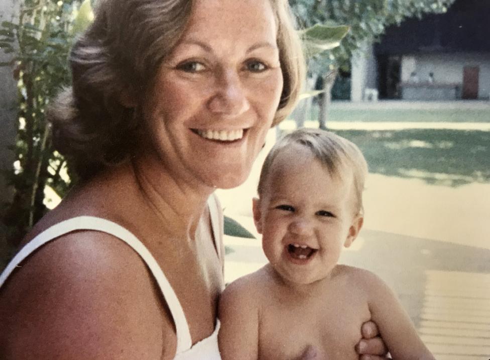 Robyn Hollingsworth as a child held by her mother outdoors