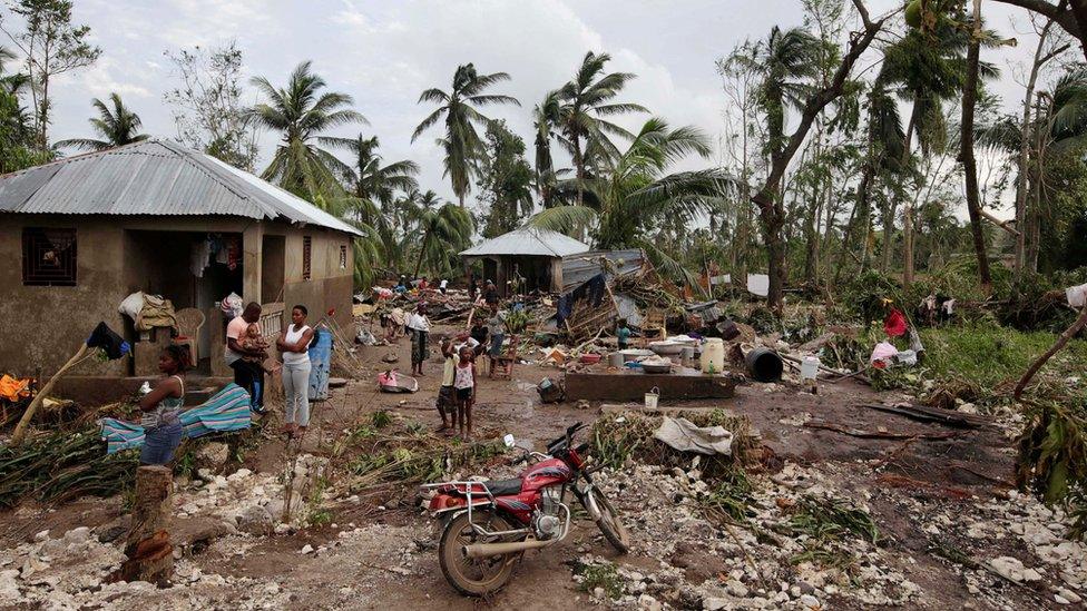 People stand in an area affected by Hurricane Matthew in Cavaillon in Haiti