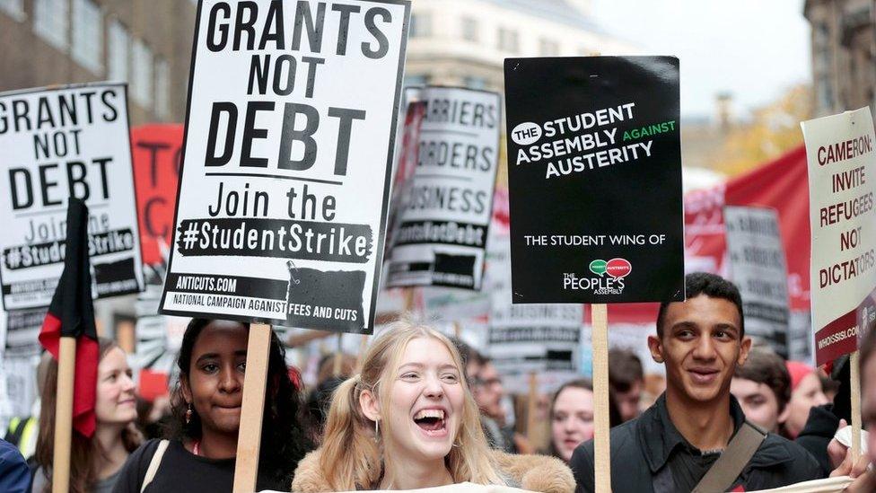 Students hold placards, and banners at the protest in London