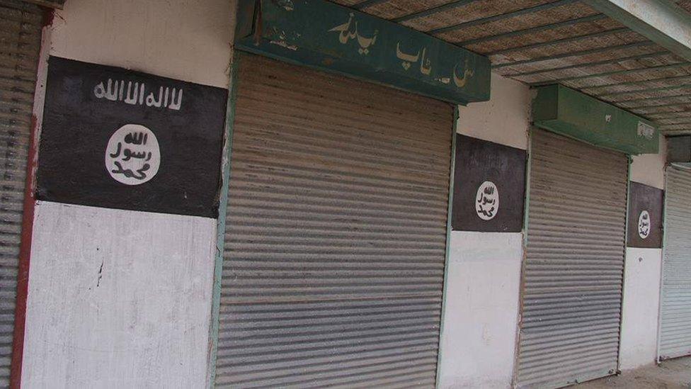 Photo released by the Nangarhar media office shows a building with the Islamic State group's flag painted on it