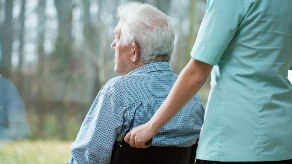 Nurse pushing a patient in a wheelchair