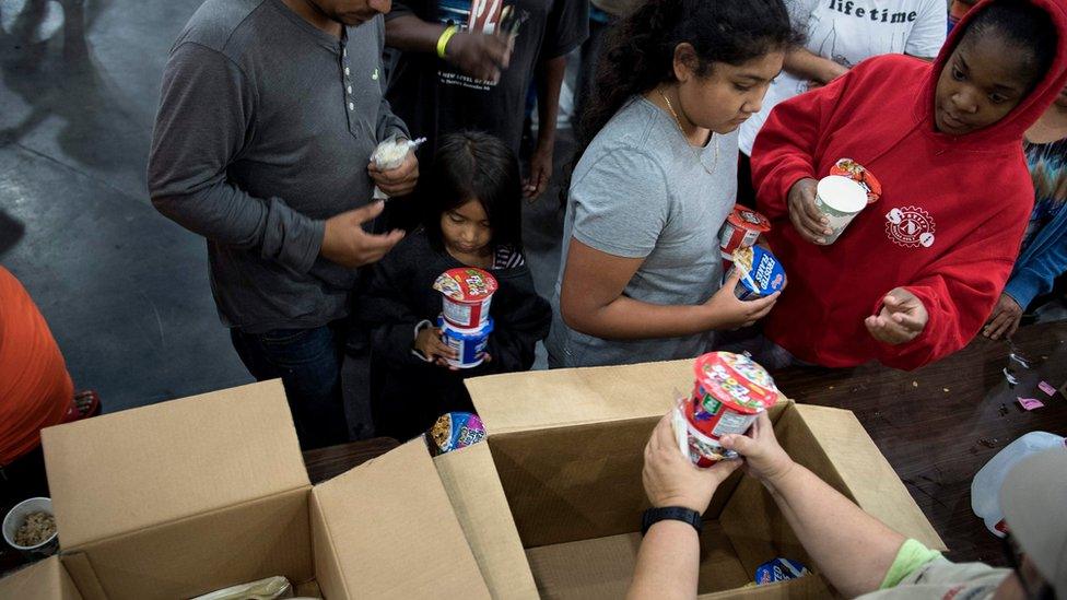 Flood victims receive food at a shelter in the George R. Brown Convention Center