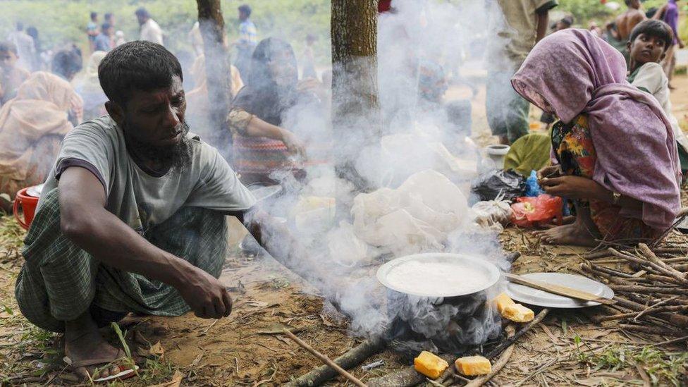 A Rohingya refugee cooks a meal