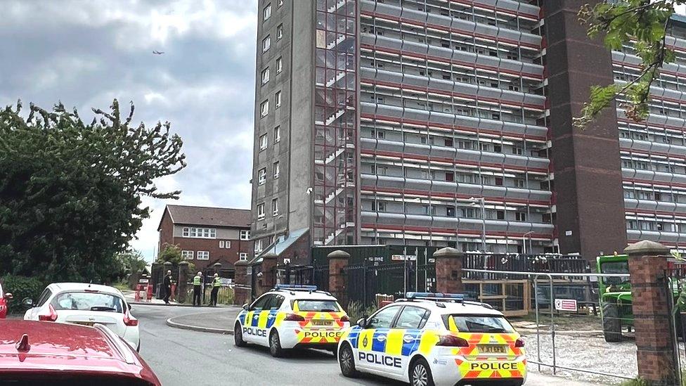 Police cars parked outside a block of flats