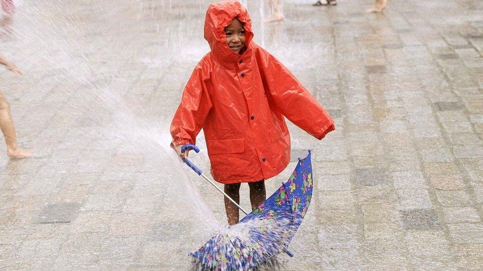 Boy in rain with umbrella