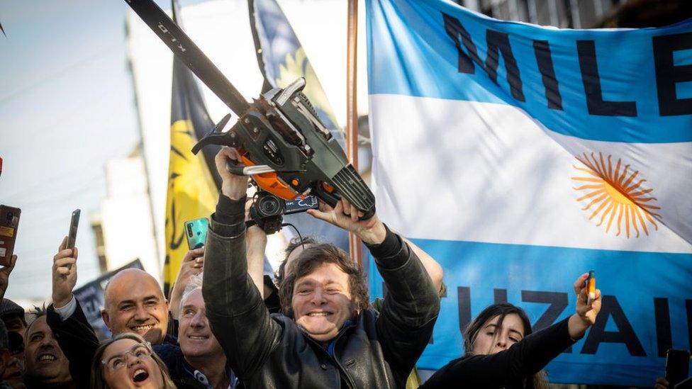 Presidential candidate Javier Milei lifts a chainsaw during a rally in September