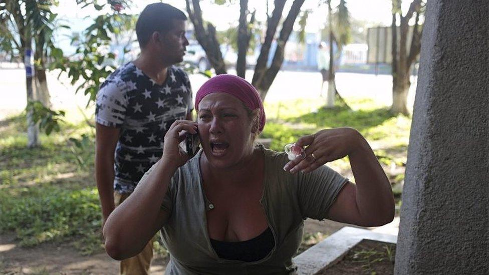 A Cuban migrants speaks on her mobile phone after riot police fired tear gas outside the customs building at the border between Nicaragua and Costa Rica on 15 November, 2015.