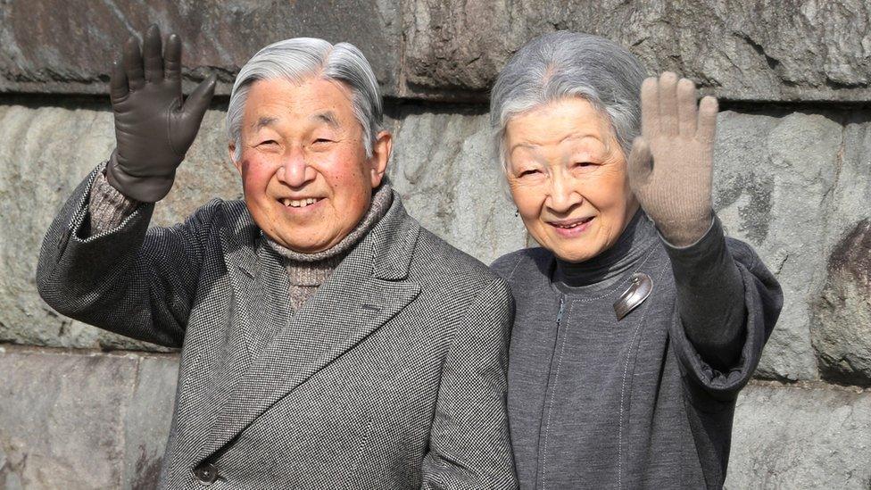 Emperor Akihito and Empress Michiko wave to locals as they take a walk on a coast near the Hayama Imperial Villa in Hayama, near Tokyo. (5 February 2016.)