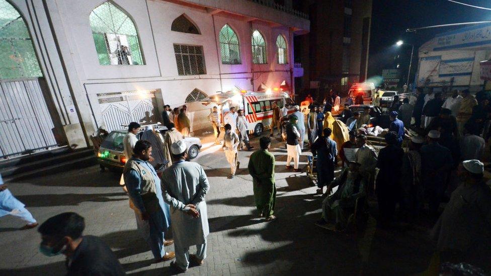 People in Pakistan stand in the streets after a deadly earthquake