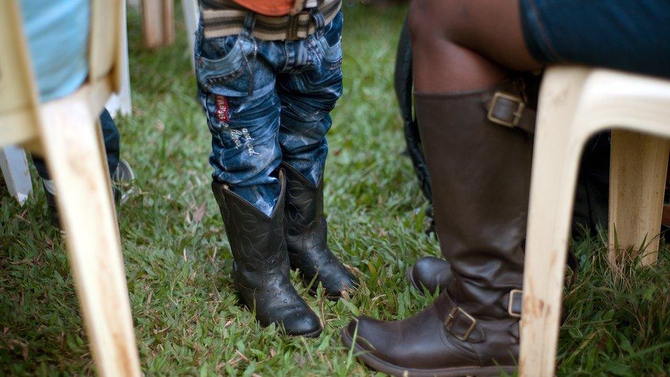 A toddler wearing cowboy boots in Kampala