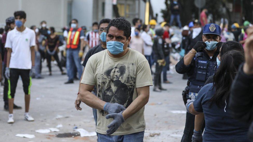 A man in a dust mask pulls on gloves