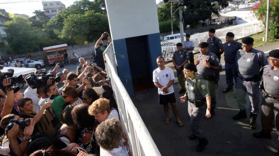 A military police officer talks with relatives of police officers who are blocking the main entrance of police headquarters, during a police strike over wages, in Vitoria, Espirito Santo, Brazil 11 February 2017.