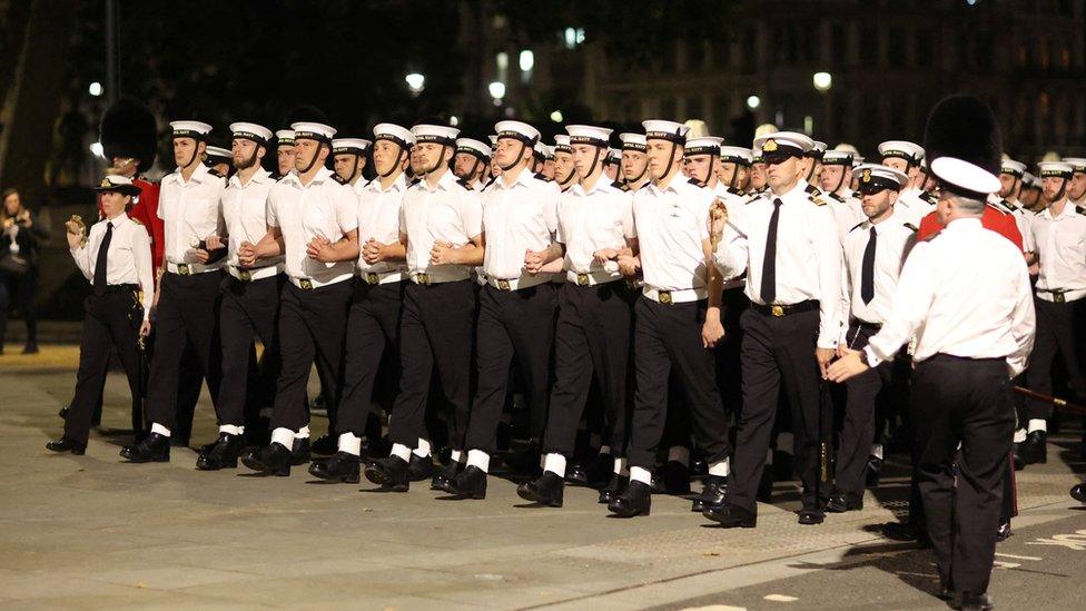 Royal Navy sailors link arms as they pull the gun carriage carrying the stand-in coffin of Britain's Queen Elizabeth, during a rehearsal for her funeral procession in London