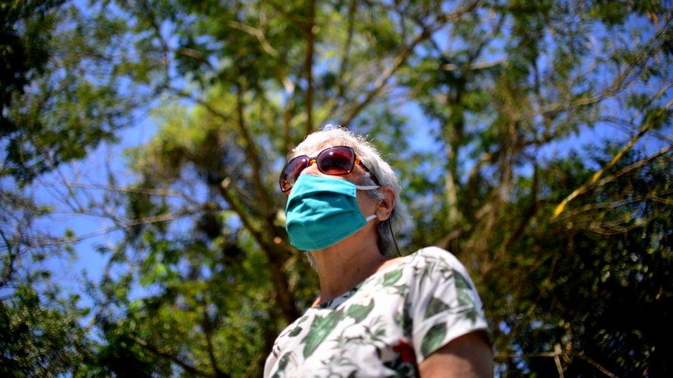 Woman wearing sunglasses and a mask - stock photo