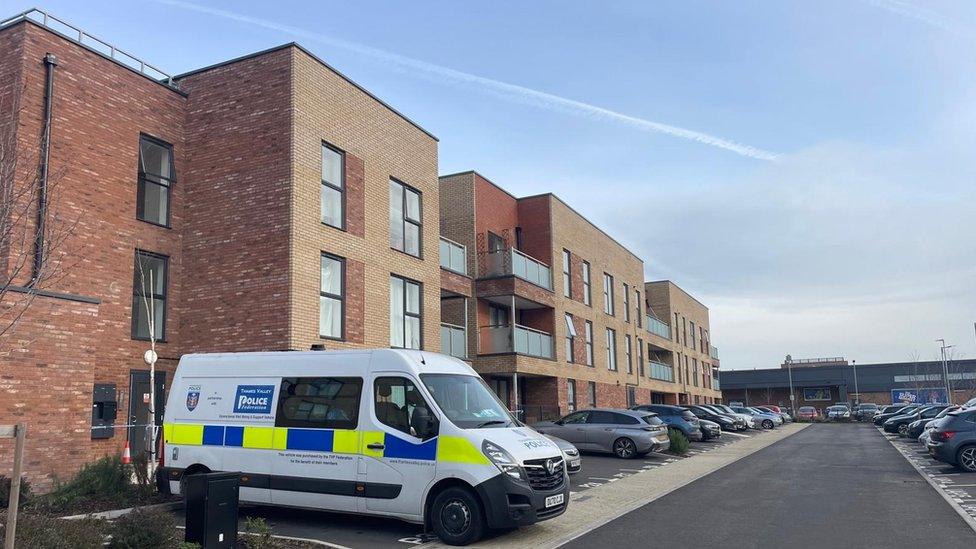 A police van parked outside a block of flats