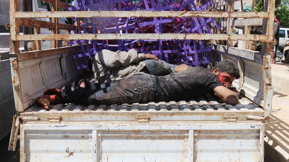 Wounded men lie in the back of a pick-up truck after an air strike in the Syrian town of Maarat al-Numan (19 April 2016)