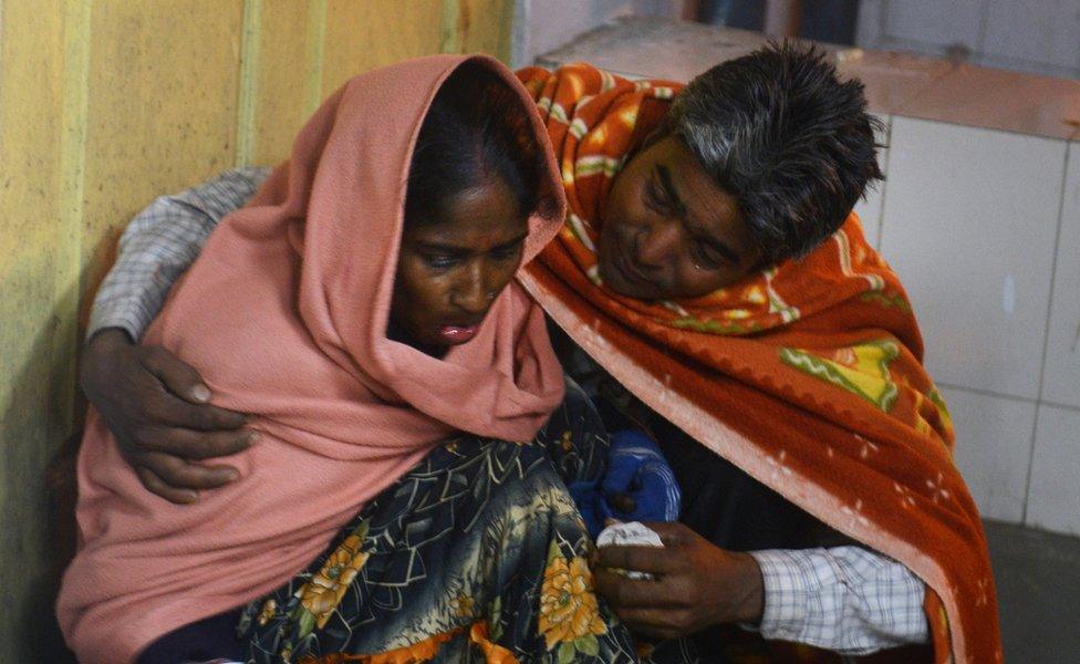 An injured Indian woman is comforted by her husband as she waits for treatment at Siliguri Hospital