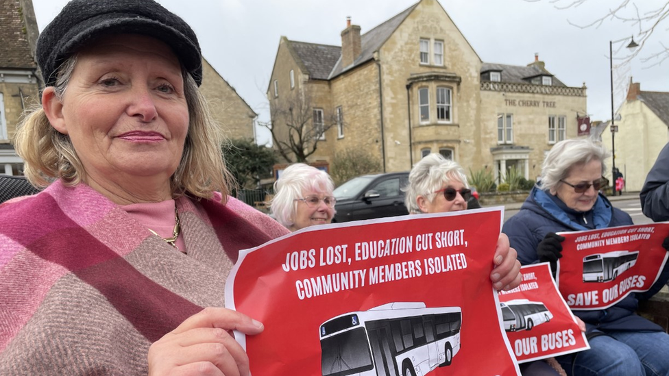 Debbie Whitworth, Olney Town Council's deputy mayor, holding a poster denouncing the bus service reduction