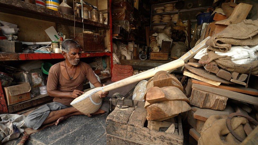 An artisan working on a sitar