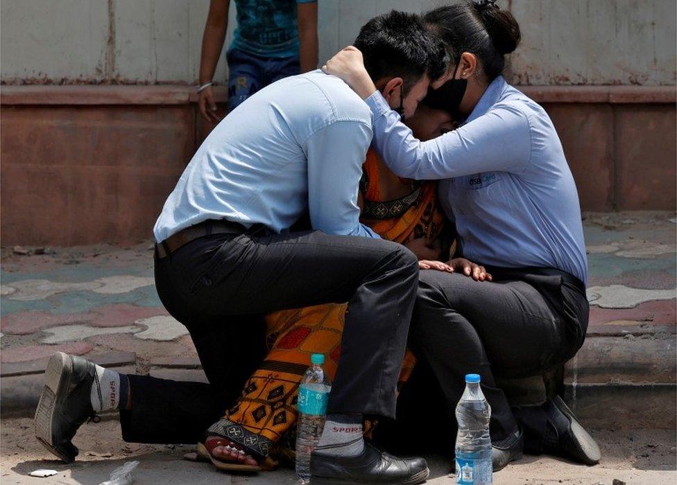 A woman is consoled by her children after her husband died from complications related to the coronavirus disease (COVID-19) outside a mortuary of a COVID-19 hospital in New Delhi, India, April 15, 2021.