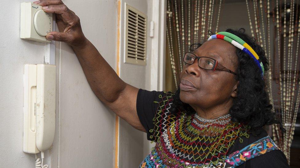 Woman adjusting thermostat