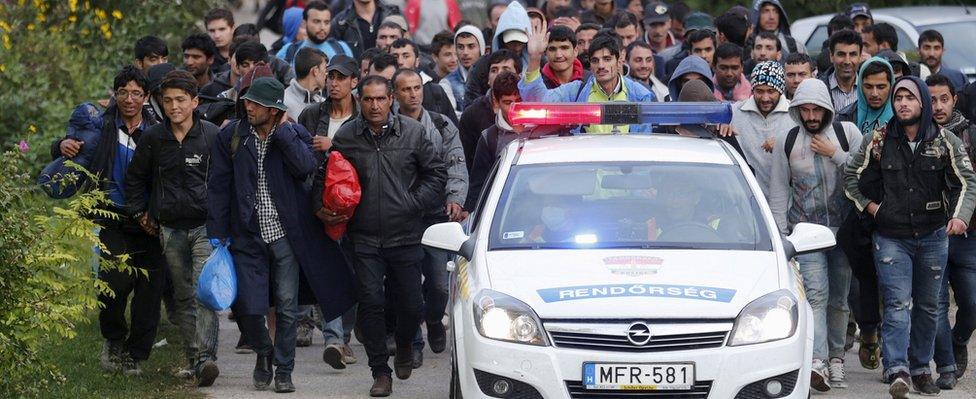 Hungarian police lead migrants on their way to Austria, in Hegyeshalom, Hungary, September 27, 2015