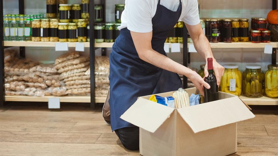 A person packs a box in a shop