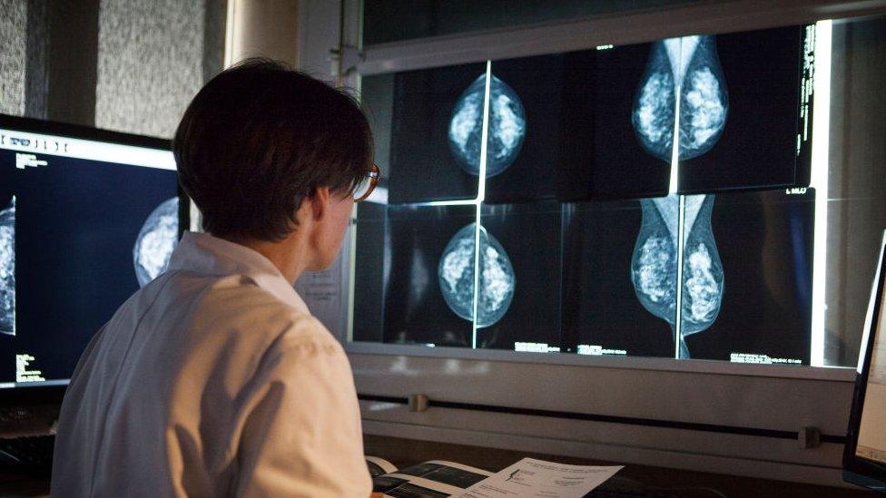 woman looks at mammogram