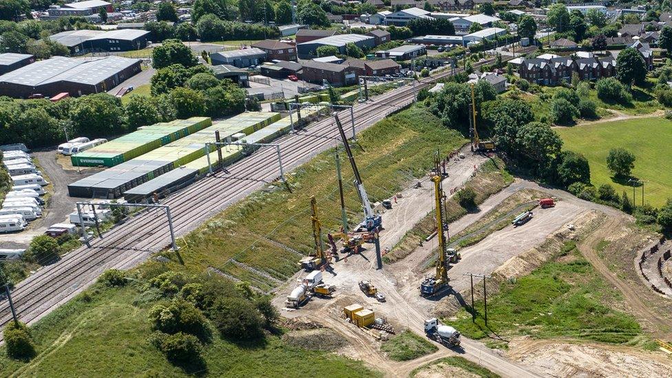 Aerial view of railway line and construction vehicles next to it