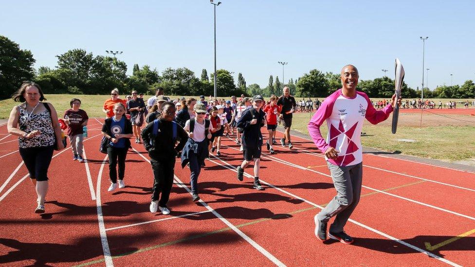 Baton bearer Colin Jackson CBE holds the Queen's Baton during the Birmingham 2022 Queen's Baton Relay on a visit to Basildon Sporting Village