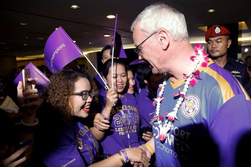 Team manager Claudio Ranieri shakes hands with supporters as he arrives with his team at Suvarnabhumi International Airport in Bangkok (18 May 2016)