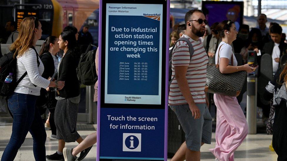 Rail passengers with an information board