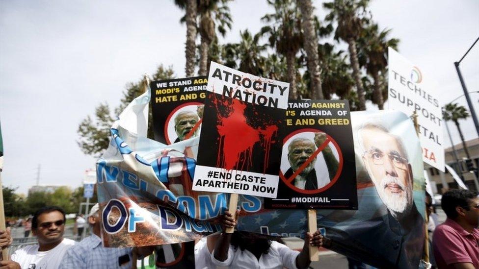 Demonstrators hold signs in protest against Indian Prime Minister Narendra Modi before a community reception outside SAP Center in San Jose, California September 27, 2015