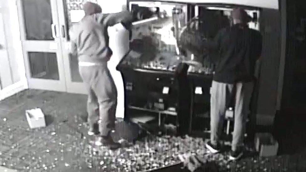 Men breaking into fruit machines in sports club