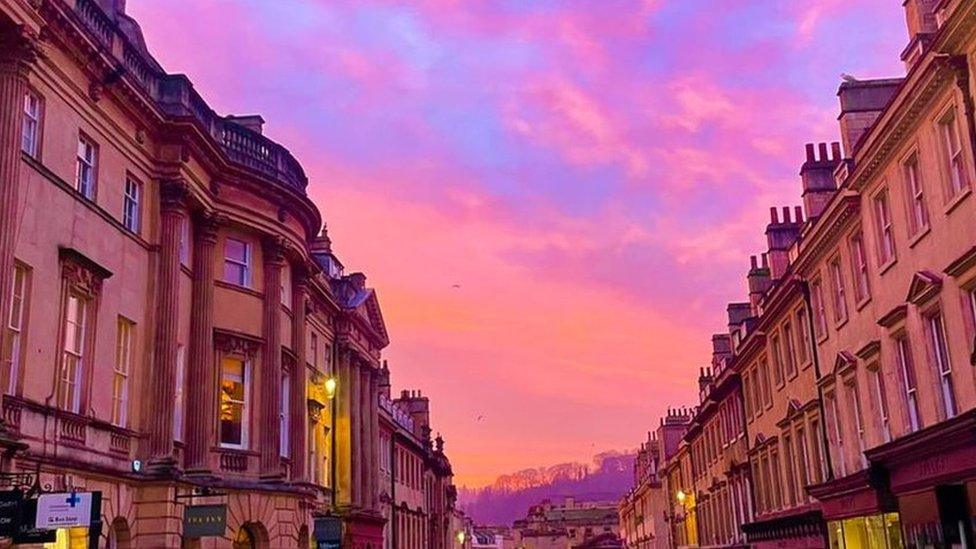 A bright pink and orange sunrise above Milsom Street in Bath