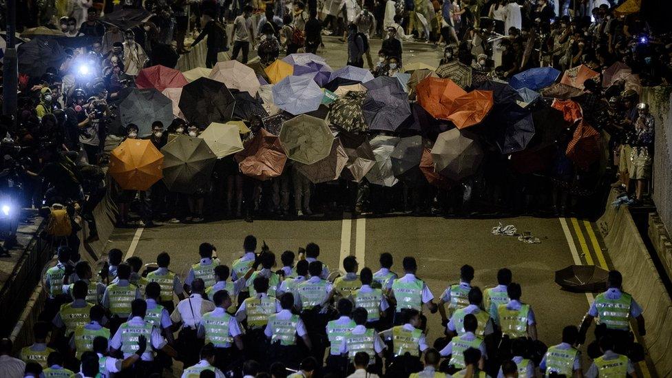 Police forces march toward pro-democracy protesters during a standoff outside the central government offices in Hong Kong on October 14, 2014