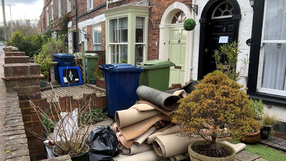 Rolls of carpet outside a house