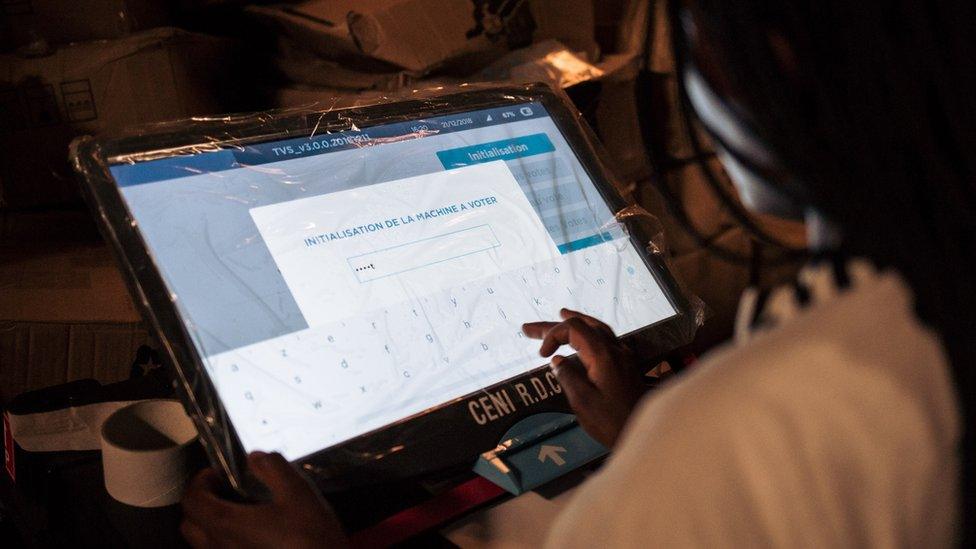 A staff of the Independent Electoral Commission (CENI) configures a voting machine on December 20, 2018