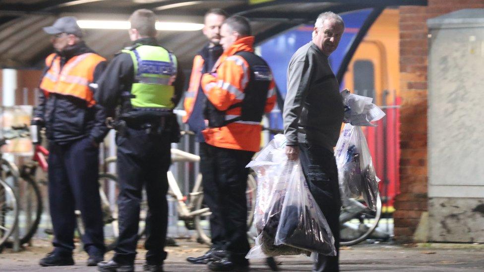 A forensics officer removes items at Horsley station