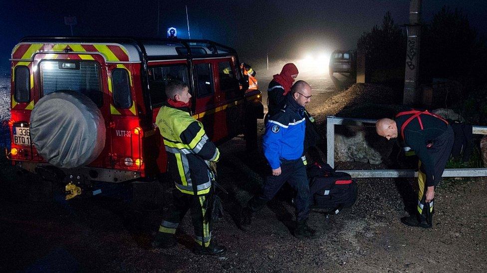 Firefighters and police near the site where a helicopter from the civil security services crashed in the hills in Le Rove, near Marseille early on December 2, 2019