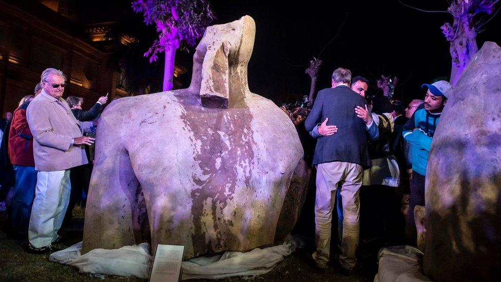 Denmark's Prince Henrik (left) looks at the statue belonging to King Psamtik I, outside the Egyptian museum in Cairo on 16 March 2017